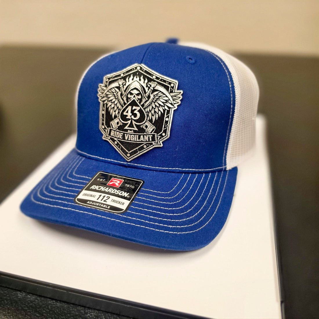 Blue and white Richardson 112 hat with The Watch Ride Vigilant leatherette patch.