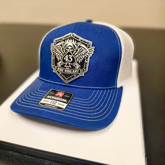 Blue and white Richardson 112 hat with The Watch Ride Vigilant leatherette patch.