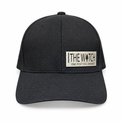 Black hat with a light-colored The Watch leatherette patch and One Post Still Manned lettering.