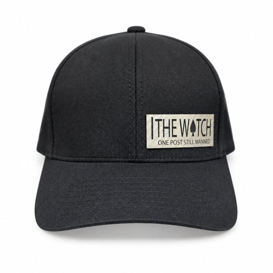 Black hat with a light-colored The Watch leatherette patch and One Post Still Manned lettering.