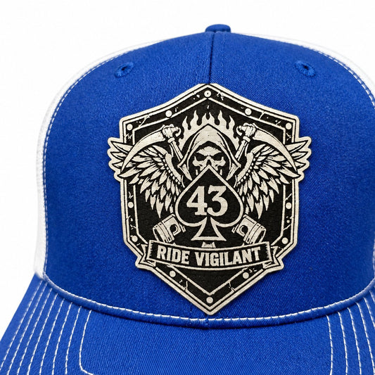 Close-up of a Ride Vigilant laser-engraved leatherette hat patch with a winged reaper and 43 spade.