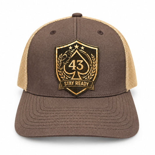 Brown and tan Richardson 112 trucker hat with a black and gold Stay Ready logo patch.